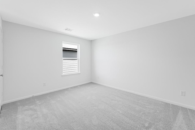 carpeted empty room featuring visible vents and baseboards