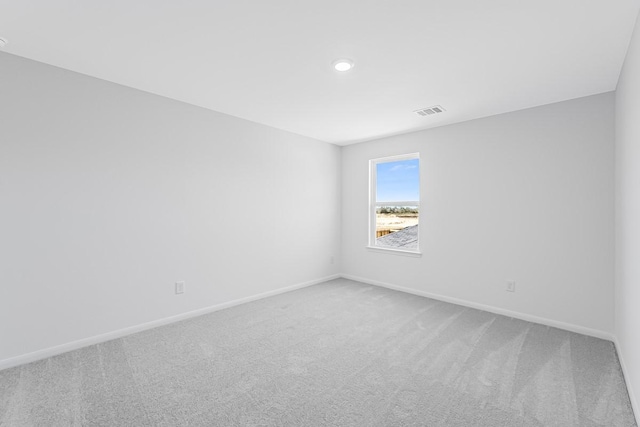 carpeted empty room featuring baseboards and visible vents