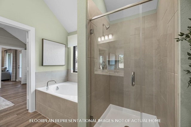 bathroom featuring a garden tub, a shower stall, vaulted ceiling, and wood finished floors