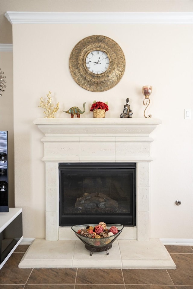 details with ornamental molding, a glass covered fireplace, and baseboards