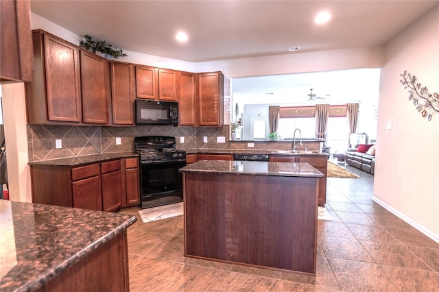 kitchen featuring a sink, a kitchen island, backsplash, and black appliances