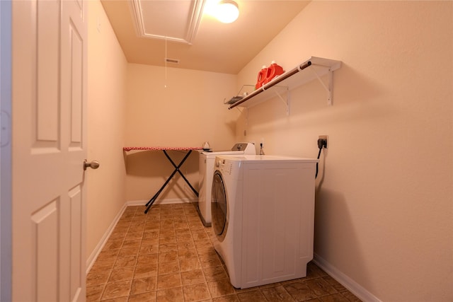 washroom with visible vents, attic access, washing machine and dryer, laundry area, and baseboards