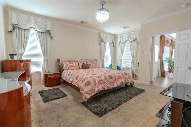 carpeted bedroom with ornamental molding, visible vents, baseboards, and an inviting chandelier