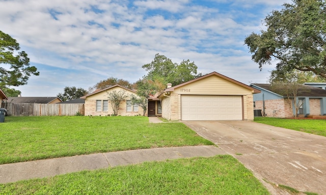 ranch-style house featuring driveway, fence, and a front yard