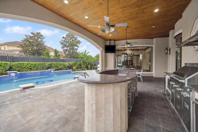 view of patio featuring a fenced in pool, a ceiling fan, a fenced backyard, exterior kitchen, and outdoor wet bar