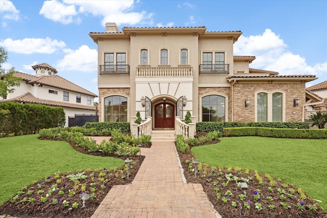 mediterranean / spanish-style home with french doors, a chimney, a balcony, and stucco siding