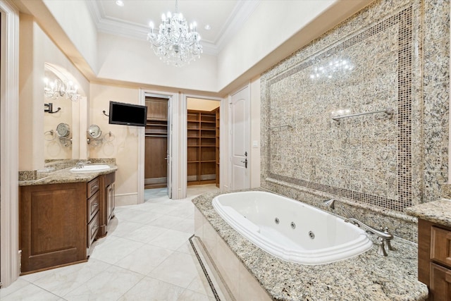 bathroom featuring a tub with jets, an inviting chandelier, a spacious closet, crown molding, and vanity