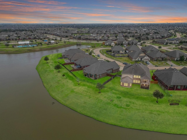 aerial view at dusk with a residential view and a water view