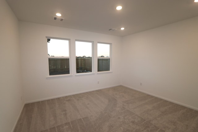 carpeted spare room with baseboards, visible vents, and recessed lighting