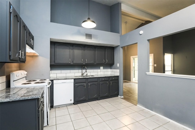 kitchen with white appliances, visible vents, decorative light fixtures, under cabinet range hood, and a sink