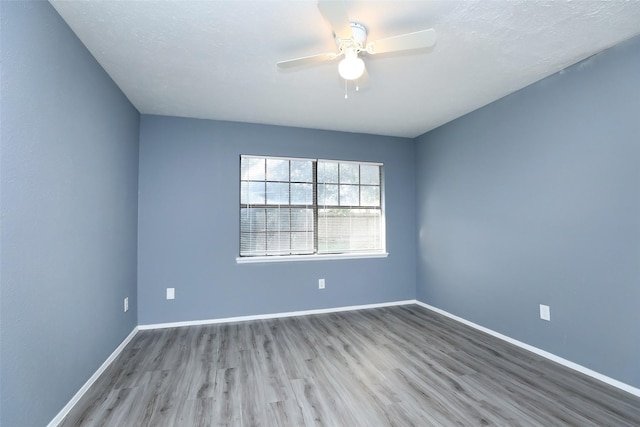 unfurnished room with a ceiling fan, baseboards, and light wood finished floors