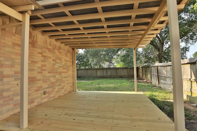 wooden terrace featuring a fenced backyard and a yard