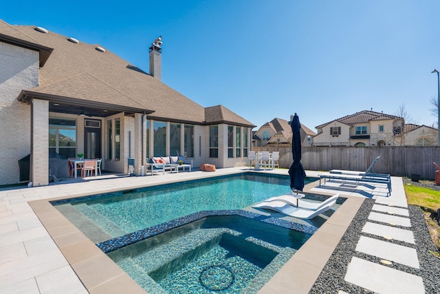 view of pool featuring a pool with connected hot tub, a fenced backyard, and a patio