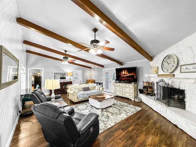 living room with lofted ceiling with beams, a fireplace, wood finished floors, and visible vents