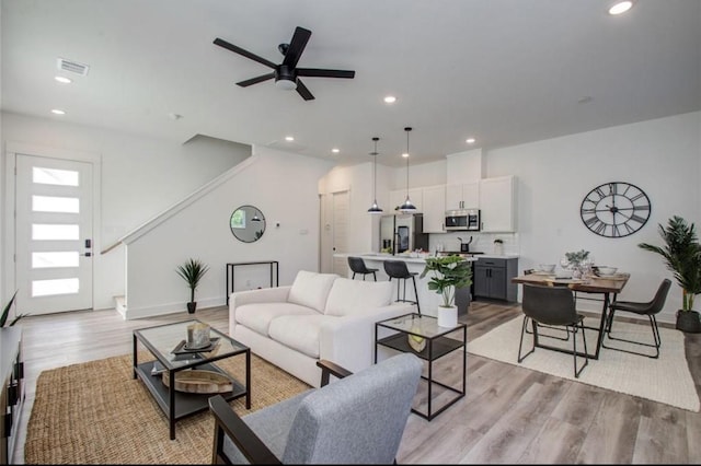 living room with light wood-style floors, recessed lighting, and visible vents