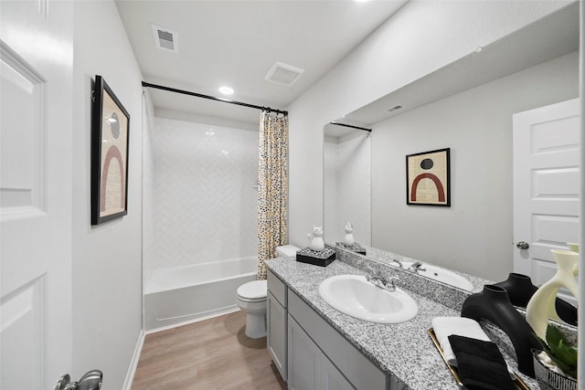 full bathroom featuring visible vents, toilet, wood finished floors, shower / bathtub combination with curtain, and vanity