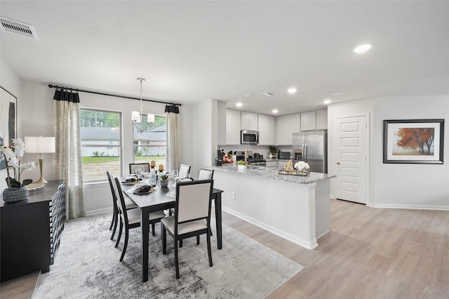 dining space with light wood finished floors, baseboards, visible vents, and recessed lighting