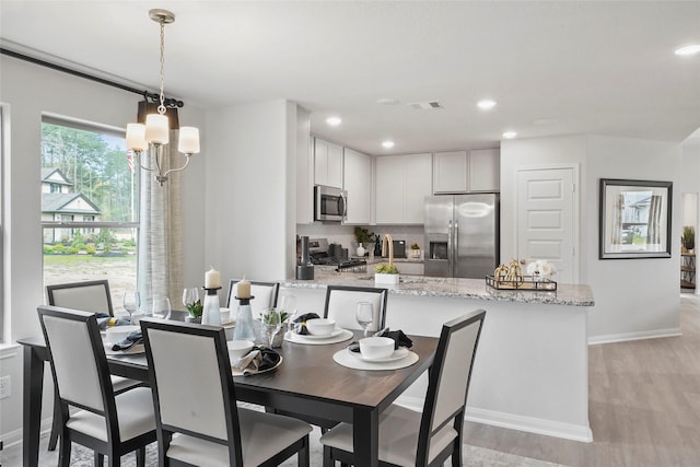 dining room featuring recessed lighting, visible vents, light wood-style flooring, and baseboards