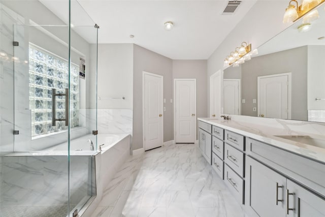 full bath with marble finish floor, a garden tub, plenty of natural light, and visible vents