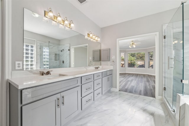 full bathroom with marble finish floor, a sink, and a shower stall