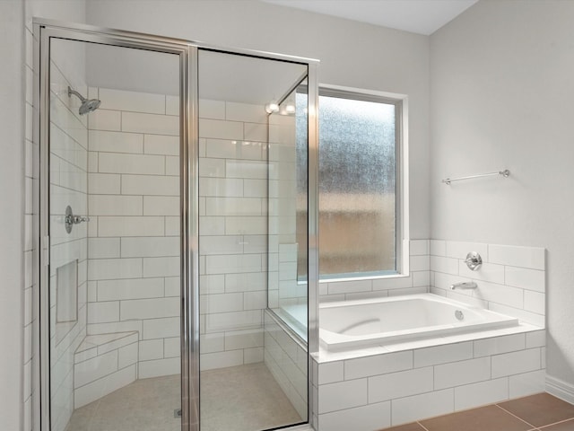 full bath with tile patterned floors, a garden tub, and a shower stall