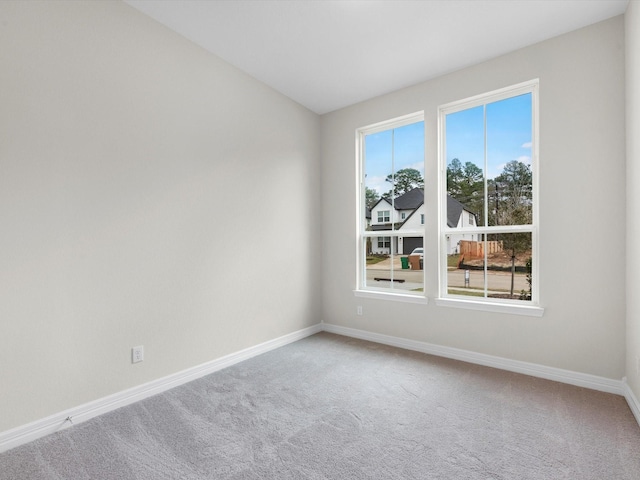 carpeted spare room featuring baseboards