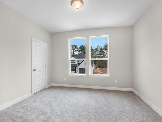 carpeted empty room featuring baseboards