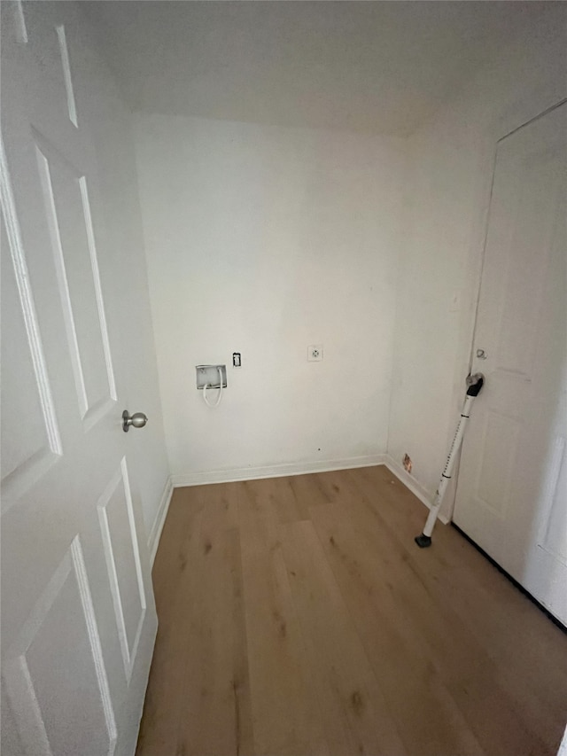 washroom with light wood-style floors, baseboards, and laundry area