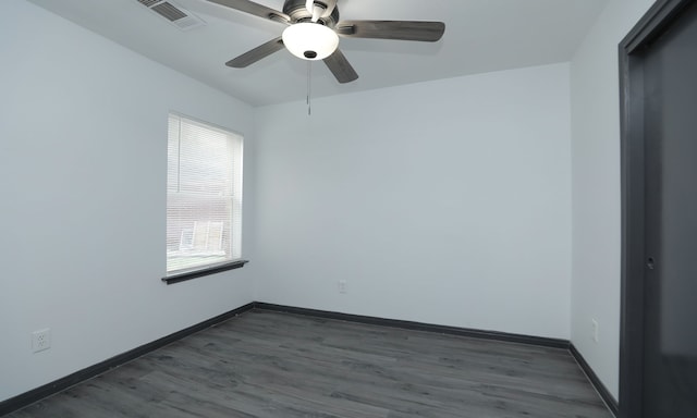 empty room featuring ceiling fan, dark wood-type flooring, visible vents, and baseboards