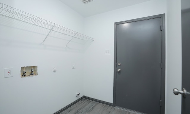 laundry area featuring washer hookup, electric dryer hookup, wood finished floors, laundry area, and baseboards