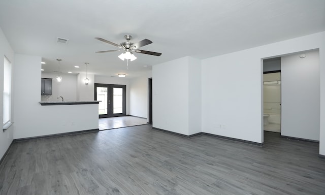 unfurnished living room with baseboards, visible vents, dark wood-style flooring, and french doors