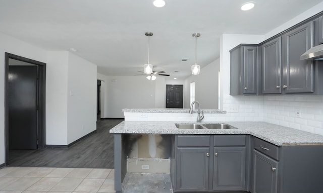 kitchen with tasteful backsplash, a ceiling fan, a sink, and gray cabinetry