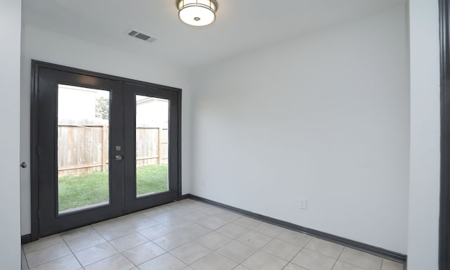 empty room featuring french doors, plenty of natural light, visible vents, and baseboards