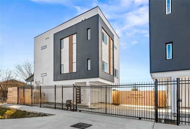 exterior space featuring a fenced front yard, a gate, and stucco siding