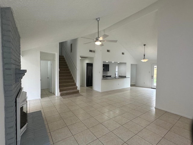 unfurnished living room featuring visible vents, stairway, a ceiling fan, light tile patterned flooring, and a textured ceiling