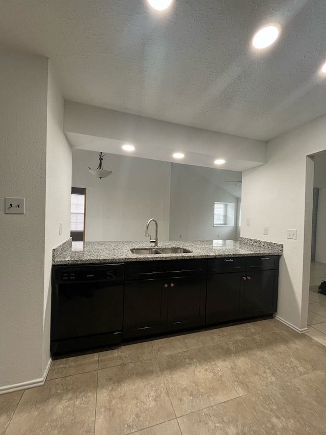 kitchen featuring a peninsula, black dishwasher, light stone counters, and a sink