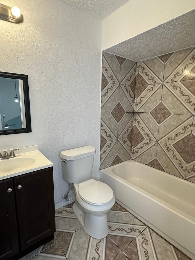 bathroom featuring a textured ceiling, tile patterned flooring, toilet, vanity, and tub / shower combination