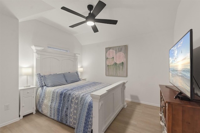 bedroom with light wood-style floors, vaulted ceiling, baseboards, and a ceiling fan