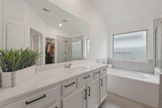 bathroom featuring vaulted ceiling, a spacious closet, and visible vents