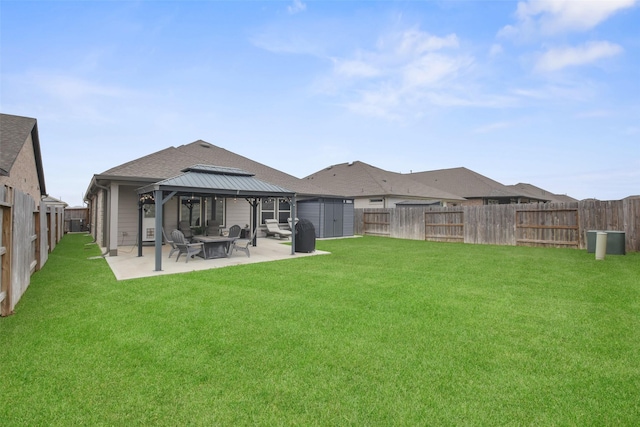 view of yard with a patio, a gazebo, a storage shed, a fenced backyard, and an outdoor structure