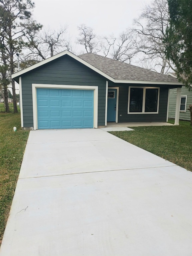 ranch-style house with an attached garage, concrete driveway, a front lawn, and a shingled roof