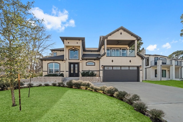 view of front of home with concrete driveway, a front lawn, an attached garage, and stucco siding