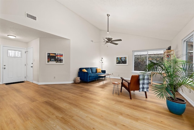 living area featuring light wood-type flooring, visible vents, and baseboards