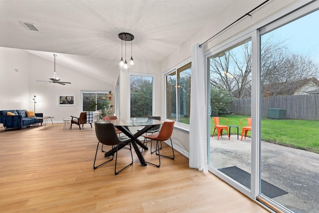 sunroom featuring lofted ceiling, visible vents, and a notable chandelier