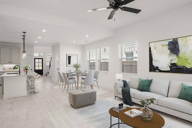 living room with a healthy amount of sunlight, light wood finished floors, stairs, and recessed lighting