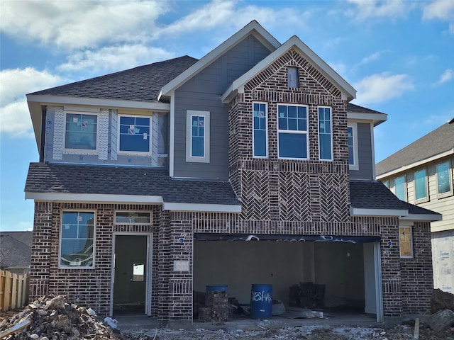 view of front of house with a garage, brick siding, and roof with shingles