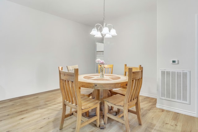 dining room with baseboards, a notable chandelier, visible vents, and light wood-style flooring