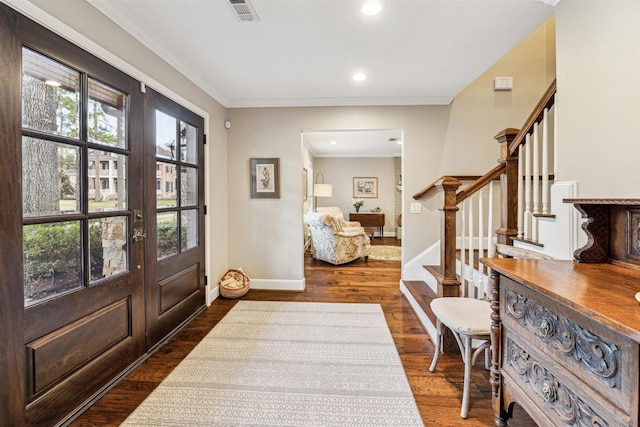 foyer entrance featuring plenty of natural light, stairs, visible vents, and dark wood-type flooring