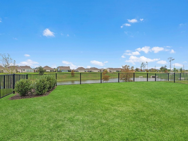 view of yard with a water view, a residential view, and fence