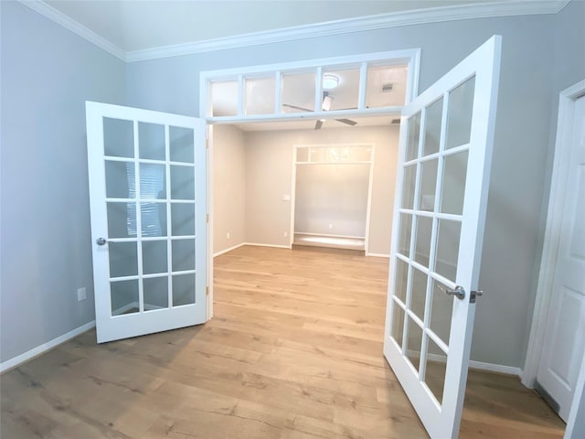 interior space featuring ornamental molding, french doors, light wood finished floors, and baseboards